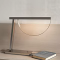 Modern Minimalist Table Lamp With Metal Frame And Glass Shade On Wooden Desk