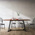 Modern wooden dining table set with metal frame chairs and green plant vase fruits