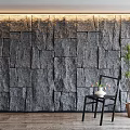Gray Stone Wall with Irregular Stone Panels Top LED Lighting Black Chair and Potted Plant