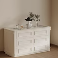 White Cabinet with Black Hat Perfume Plant in Beige Room with Window and Wooden Floor