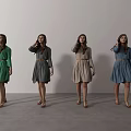 Women in Belted Colored Dresses Standing in a Row Against White Background