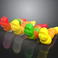 Colorful Gummy Worms With Red Yellow Green Smiley Face Shapes On Black Surface