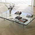 Modern Glass Coffee Table With Decorative Vase And Stacked Books On Surface