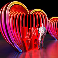 Vibrant Neon Heart Sculpture With LOVE Lettering And Cupid Design Featuring Person