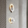 Three Modern Wall Sconces With Golden Base Illuminated Ring On Gray Textured Wall 3d model