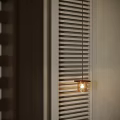 Glass Pendant Light Emitting Warm Glow Beside White Window Blinds in Interior