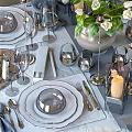 Elegant Dinnerware Set With White Flowers Vase Candles Glassware And Silver Cutlery