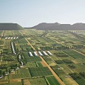 Aerial View of Green Farmland With Neat Plots Distant Mountains And White Sheds