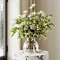 Clear Glass Vase With White Flowers Green Foliage On Patterned Table Near Window Snowy Pines