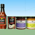 Assorted Thai Condiment Bottles and Jars Including Coconut Milk Red Curry Paste and Chili Sauce