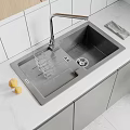 Stainless Steel Kitchen Sink with Faucet Drainer Rack and Glasses on White Countertop with Cabinets