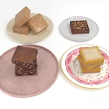 Various Square Shaped Desserts On Different Plates With Nutty And Creamy Layers