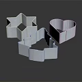 Delicate Metal Cookie Cutters with Star Heart Christmas Tree Shapes on Black Reflective Background