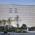 Modern Building With Glass Curtain Wall Metal Frames Landscaped Areas And Pedestrians Walking