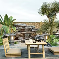Rockery Stones With Waterfall Bamboo Fence And Plants In Natural Outdoor Garden With Table Chairs