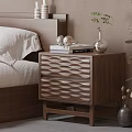 Modern Wooden Bedside Table With Wavy Drawers And Books Silver Vase Small Green Plant In Bedroom