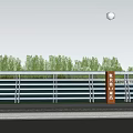 Metal Railing With Glass Panels Along Riverside Road And Green Vegetation