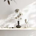Dandelion Like Flowers In Black Vase On Tabletop With White Wall And Light Shadows