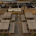 Outdoor Gathering Area With Tent Canopies Picnic Tables Storage Boxes And String Lights On Sand