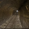 Old Stone Tunnel Interior With Wooden Railway Track And Distant Light