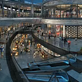 Modern Commercial Street With Multi Level Glass Facades Shops Pedestrians And Escalators
