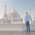 Spiritual individual standing before white religious spires and pagodas on stone pavement under clear sky