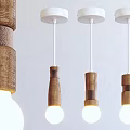 Three Modern Wooden Pendant Lights with White Base and Warm Glowing Bulbs
