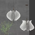 Modern White Wavy Pendant Light With Warm Glow Against Gray Wall And Green Plant