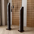 Two Black Columnar Decorative Objects In Interior With Wooden Slat Wall And Green Plant