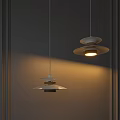 Modern Pendant Lights With Layered Design And Warm Glow Hanging Against Gray Wall