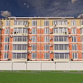 Multistory Apartment Building Exterior With Red Brick Yellow Facade Windows Green Lawn And White Fence