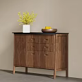 Wooden Sideboard Featuring Black Countertop White Vase Yellow Flowers And Brown Bowl With Yellow Fruits