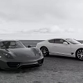 Black And White Luxury Sports Cars Parked On Open Road With Cloudy Sky Background