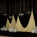 Elegant Floral Installation with Golden Conical Drapes White Flowers and Hanging Decorations on Black Background