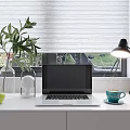 Modern Laptop on White Desk with Green Apples Plant Lamp and Blue Cup