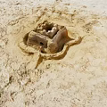Intricate Sandcastle Structure On Sandy Ground With Detailed Design And Small Openings