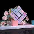 Colorful Brand Logo Cube Display With Pink Flowers And Decorative Elements