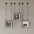 Wooden Frames With Black And White Photos Hanging On Gray Wall With Chains