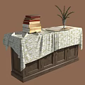 Dark Wooden Cabinet With Patterned Tablecloth Stack Of Books And Vase Plant