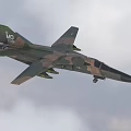 Military Camouflage Fighter Jet Flying Through Clouds With Weapon Pylons