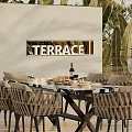 Outdoor Terrace Dining Table Set With Woven Chairs And Green Plants
