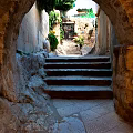 Scenic Stone Alleyway With Steps Archway Lush Greenery And Old Buildings