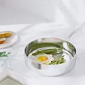 Fried Egg With Green Beans Cooking In Stainless Steel Pan And Bread On Marble Countertop