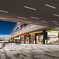 Modern Commercial Street With Vibrant Storefronts Outdoor Lighting And Pedestrian Walkway