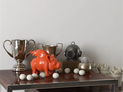 Orange Pig Sculpture with Silver Trophies Black Container White Golf Balls and Succulents on Table 3d model