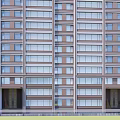 Modern High Rise Building Exterior Design With Glass Windows And Surrounding Green Trees