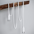 White USB Data Charging Cables Hanging On Wooden Holder With USB Port
