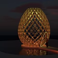Golden Egg Shaped Art Installation Featuring Diamond Lattice Design And Illuminated Ring On Water Surface