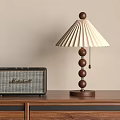 Modern Table Lamp With Pleated Shade And Wooden Base Next To Marshall Radio On Wooden Cabinet