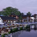 Traditional Style Commercial Street Along Waterfront With Nighttime Lighting And Pedestrian Activity